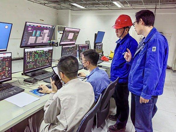 5月13日，動力車間三期鍋爐控制室，DCS改造工藝、儀表、電氣等部門聯(lián)合調(diào)試，車間主任姜軍虎與技術員畢加佳查看調(diào)試過程.jpg