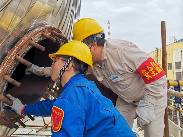 10月17日下午，在52工段除氧器人孔外，屈煒正在給董宇斌講述內(nèi)部構(gòu)造及工作原理。.jpg